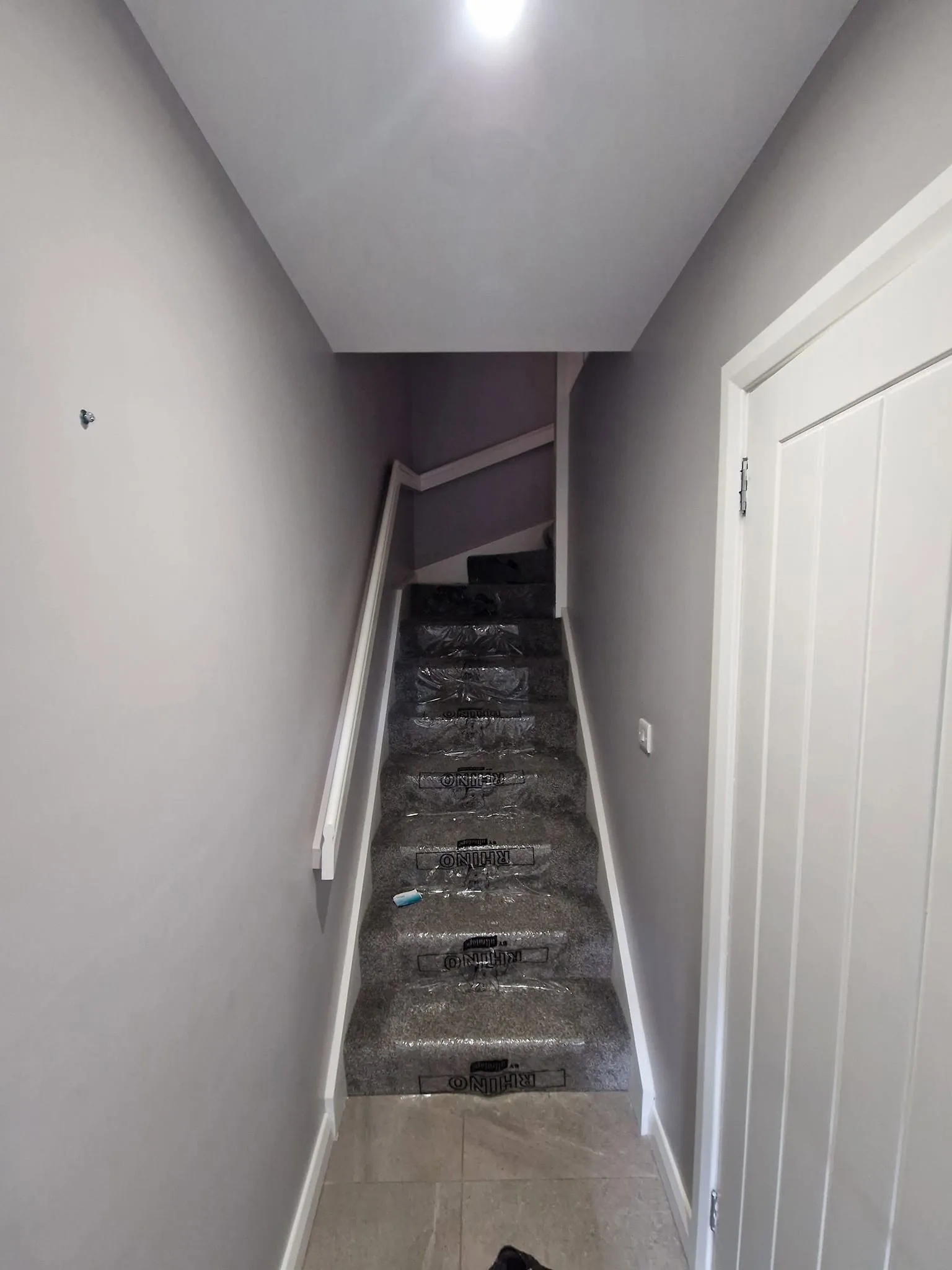 Rhino self-adhesive film laid over a stair carpet, covering every tread and riser up the flight.