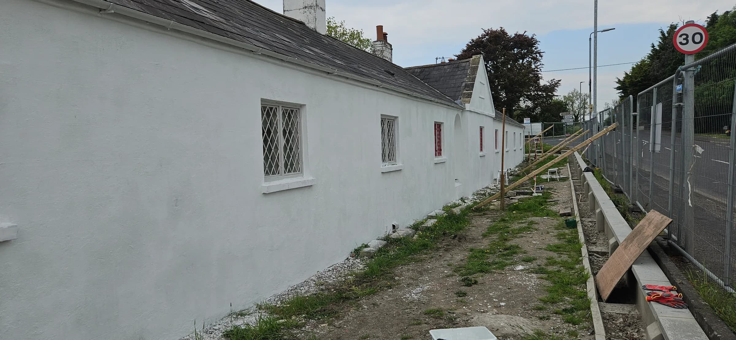 The end elevation freshly whitened, window frames not yet painted, kerb works still in progress
